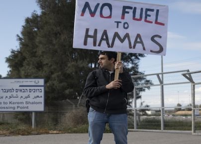 إسرائيلي يحمل لافتة ضد دخول المساعدات الإنسانية إلى قطاع غزة