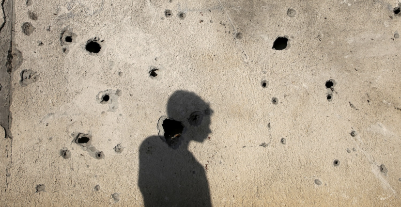 ظل طفل على جدار اخترقته شظايا قذائف جيش الاحتلال الإسرائيلي