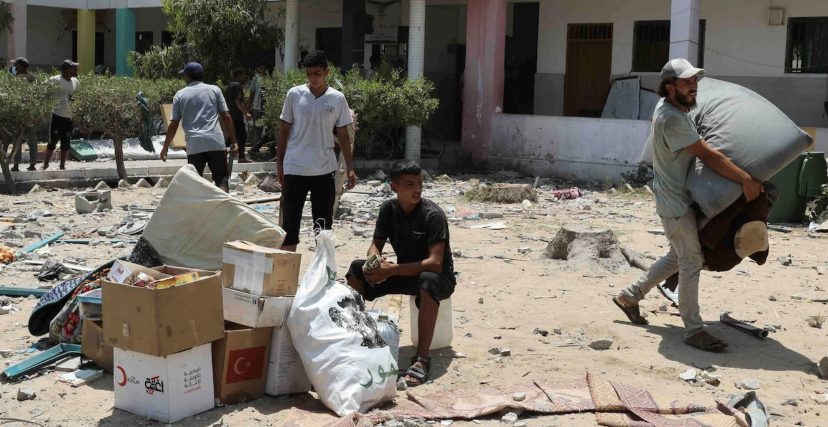 فلسطينيون يغادرون مدرسة تعرضت للقصف في دير البلح